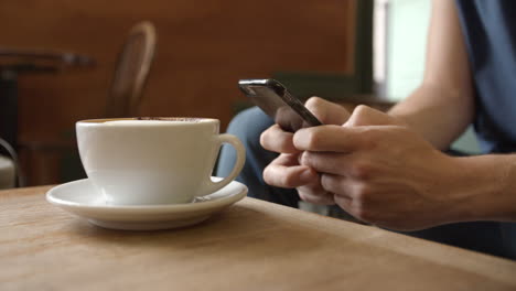 Man-messaging-with-smartphone,-surface-level-close-up-detail