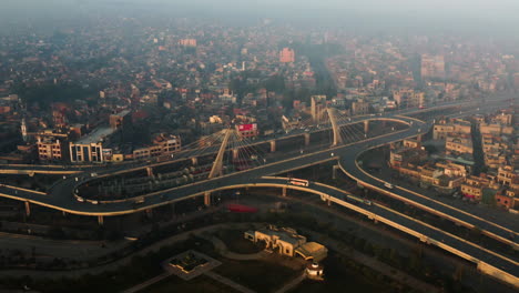 Blick-Von-Oben-Auf-Den-Großen-Kreisverkehr-Bei-Sonnenaufgang-In-Lahore,-Pakistan---Drohnenaufnahme-Aus-Der-Luft
