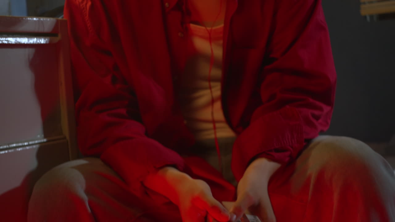 슬픈 우울한 아시아 남성이 침실에서 헤드폰으로 음악을 듣고 있습니다.