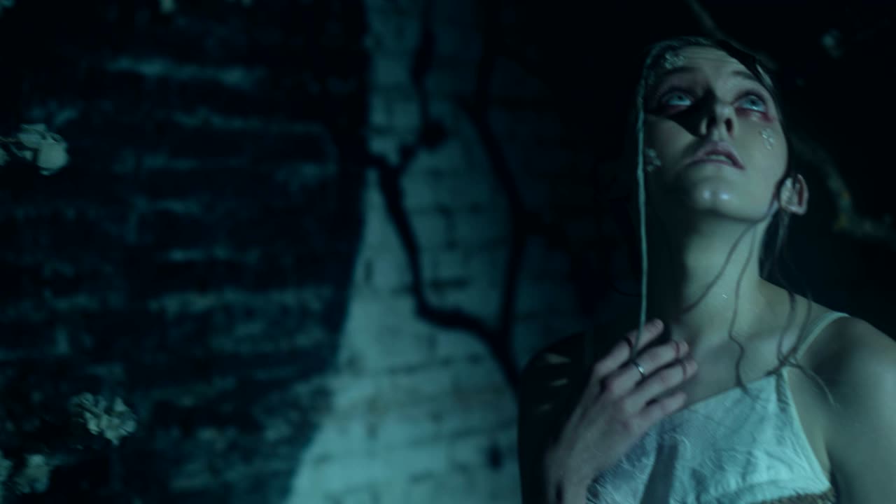 una mujer extraña con maquillaje de moda creativo está posando mirando a su alrededor