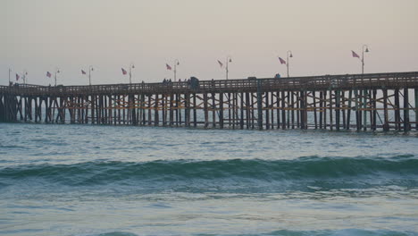 panning shot to end of ventura pier as waves roll though the pacific ocean located in southern california