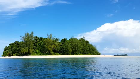 idyllic tiny remote tropical island with white sandy beach, green trees and blue ocean water in bougainville, papua new guinea