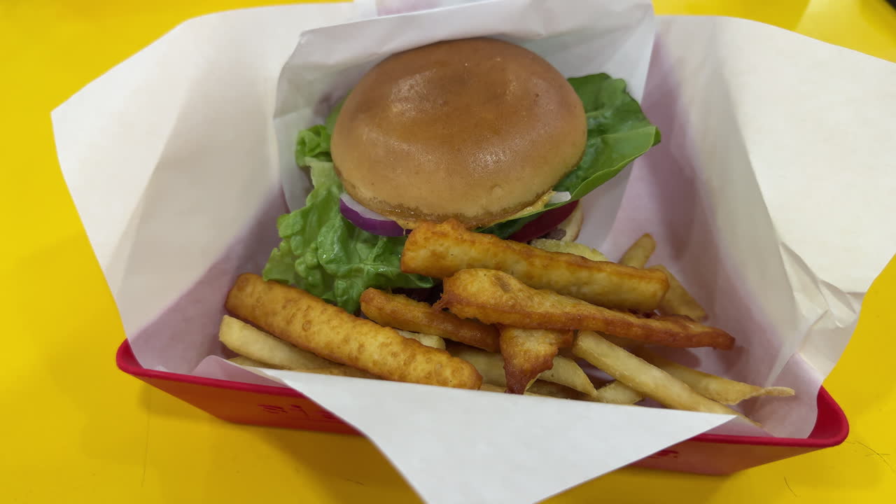 Paper tray burger with fries, panned smoothly in slow motion