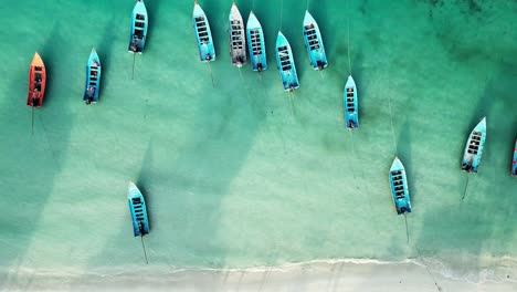 aerial view of boats floating in the turquoise waters of koh phangan, thailand, with vibrant coral reefs below the surface