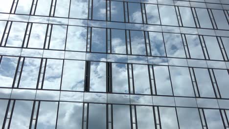 time lapse of a blue summer sky with clouds reflecting off the glass facade of an office building