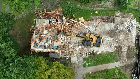 aerial view of building demolition with excavator and debris