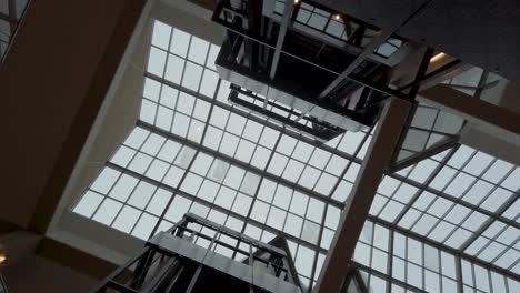 modern building atrium with glass ceiling and elevators