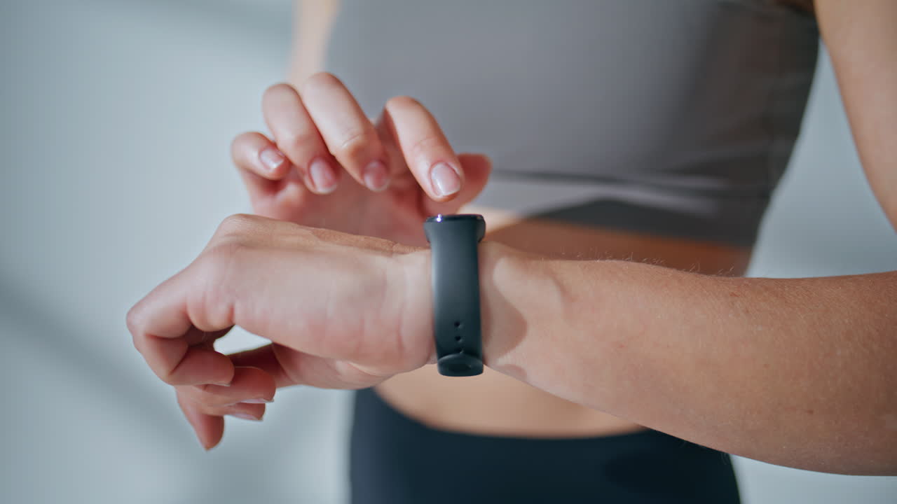 Hands touching smart watch closeup. Sportswoman tapping screen display indoors