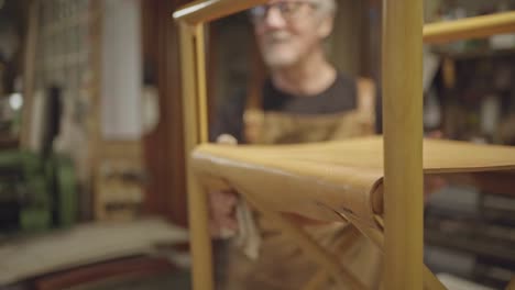 selective-focus-on-chair-while-being-moved-by-leather-craftsman-while-cleaning