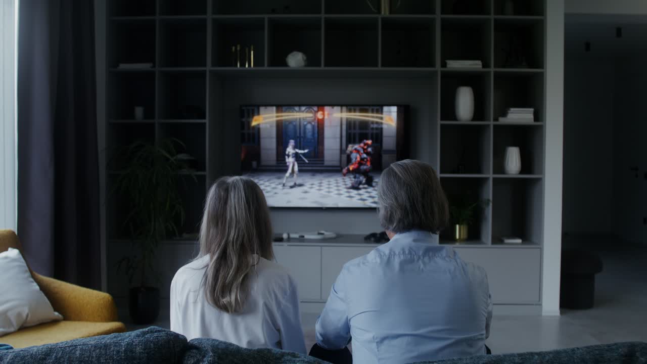 Una coppia guarda la TV nel proprio salotto