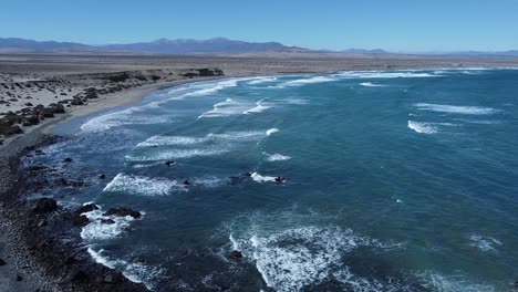 in the image you can see from an aerial shot a beach in front of small cliffs