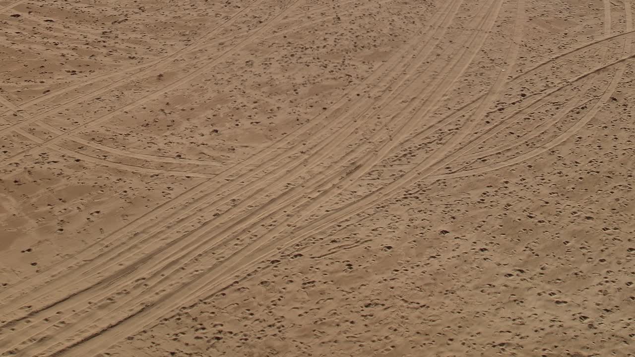 Tracks in the sand across the desert landscape in Morocco during daytime
