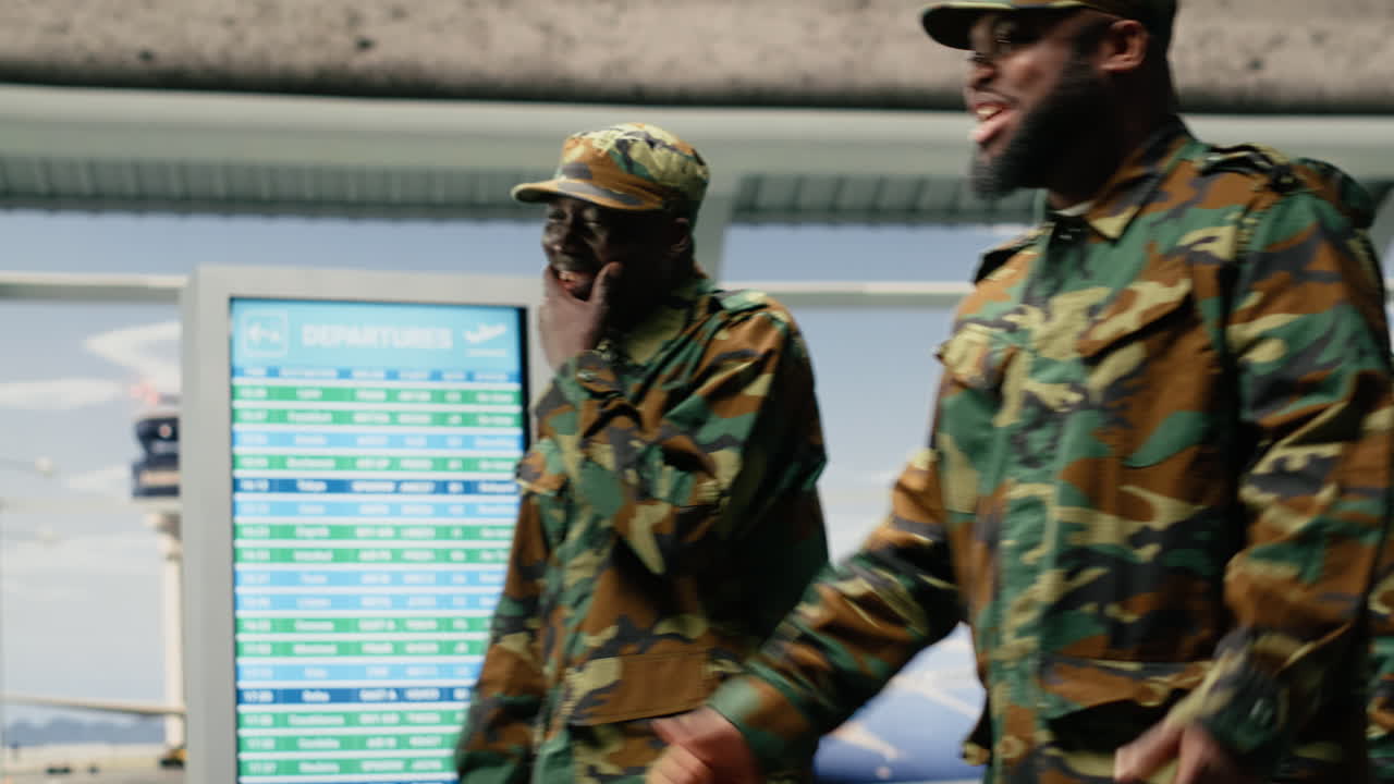 Militari nella lounge che attraversano un aeroporto affollato.