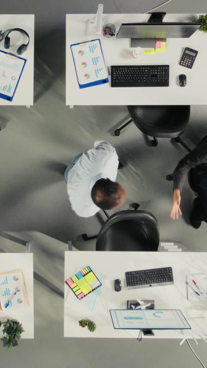 Lodret video: Top-down-view af kollegaer i en multinational virksomhed, der hilser på hinanden