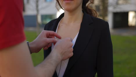 una mujer está equipada con un micrófono de pecho en preparación para la producción de video, capturando el trabajo detrás de escena de los profesionales de los medios