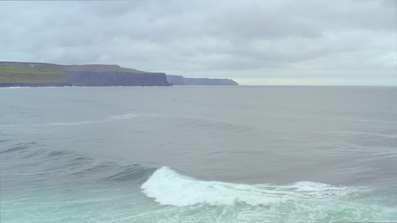 Aerial dolly glides from Crab Island’s rugged ground to the vast Atlantic, with Cliffs of Moher in the distance