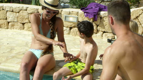 familia de vacaciones relajándose en la piscina al aire libre