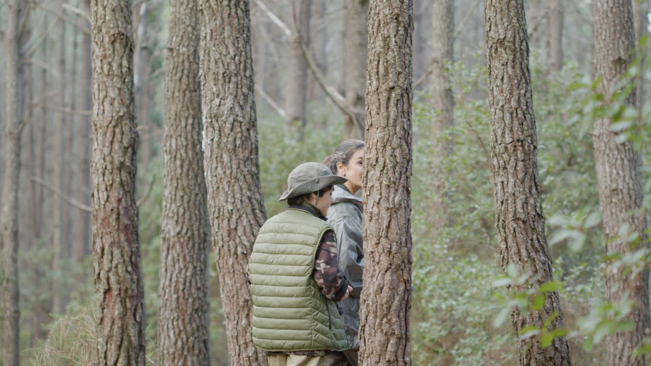 小孩子和他的母亲在森林里散步,并拍摄野生动物的照片