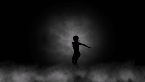 A-modern-youth-dance-performed-by-a-graceful-and-sexy-female-silhouette,-in-the-smoke-against-the-backdrop-of-spotlights