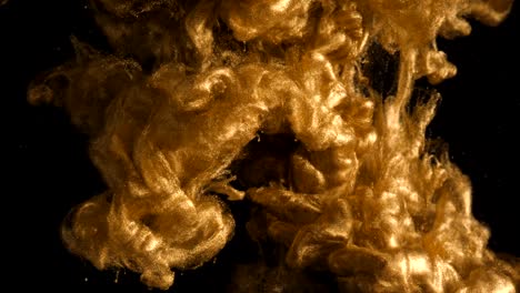 ink in water. colour golden glitter paint reacting in water creating abstract cloud formations.can be used as transitions,added to modern grunge projects,art backgrounds, anything with creative twist