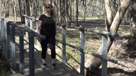 outdoor nature blonde woman walking on bridge in nature
