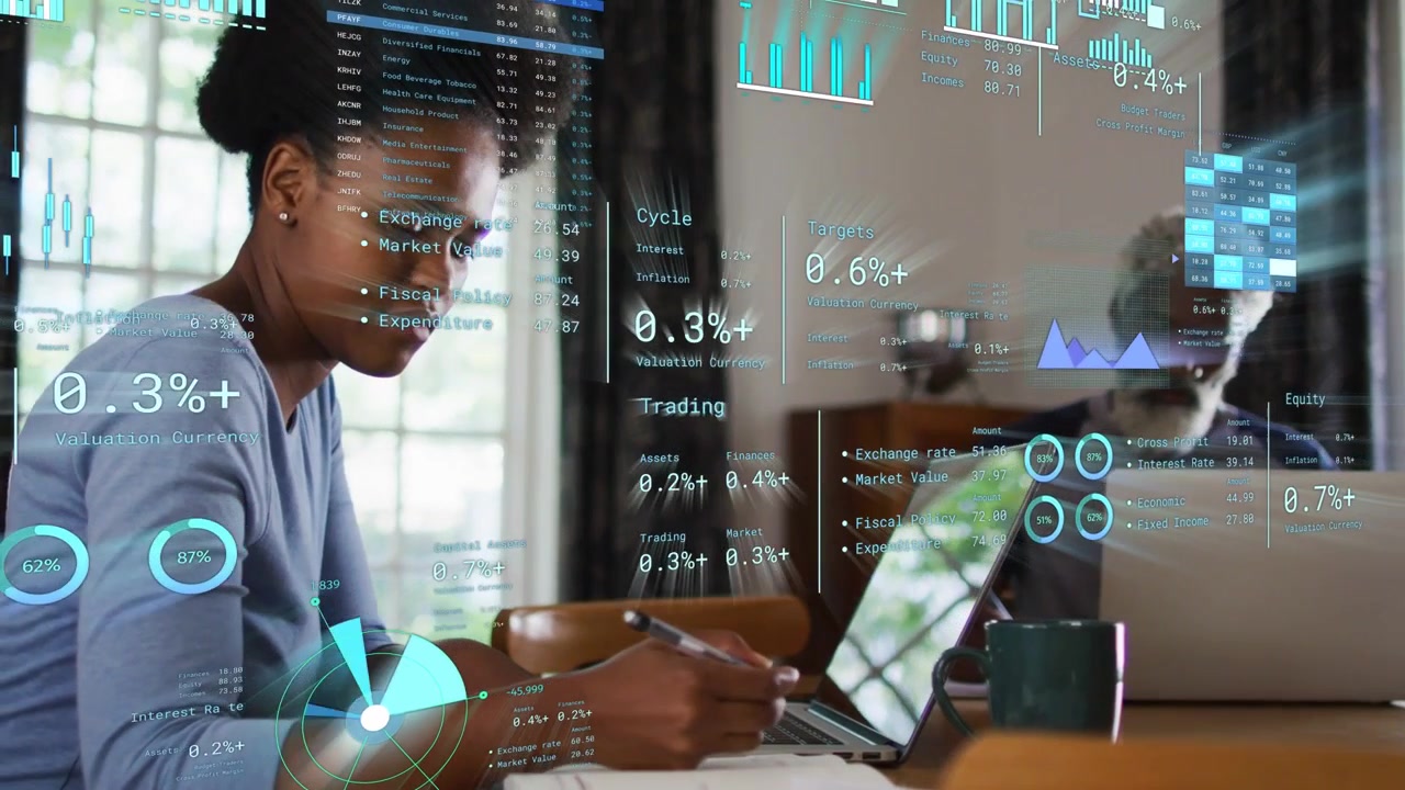 HUD overlays appearing, woman writing notes and referencing laptop while visualizing financial data