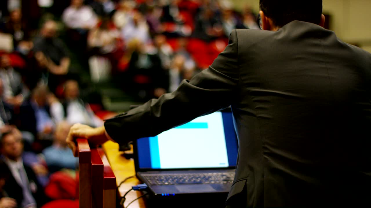 un hombre da un discurso a la audiencia en un auditorio en una convención de economía y finanzas de su negocio y aplaudir su discurso