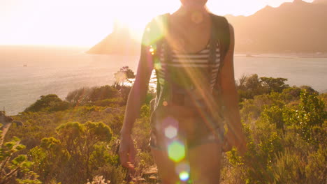 group of friends walking along coastal path together