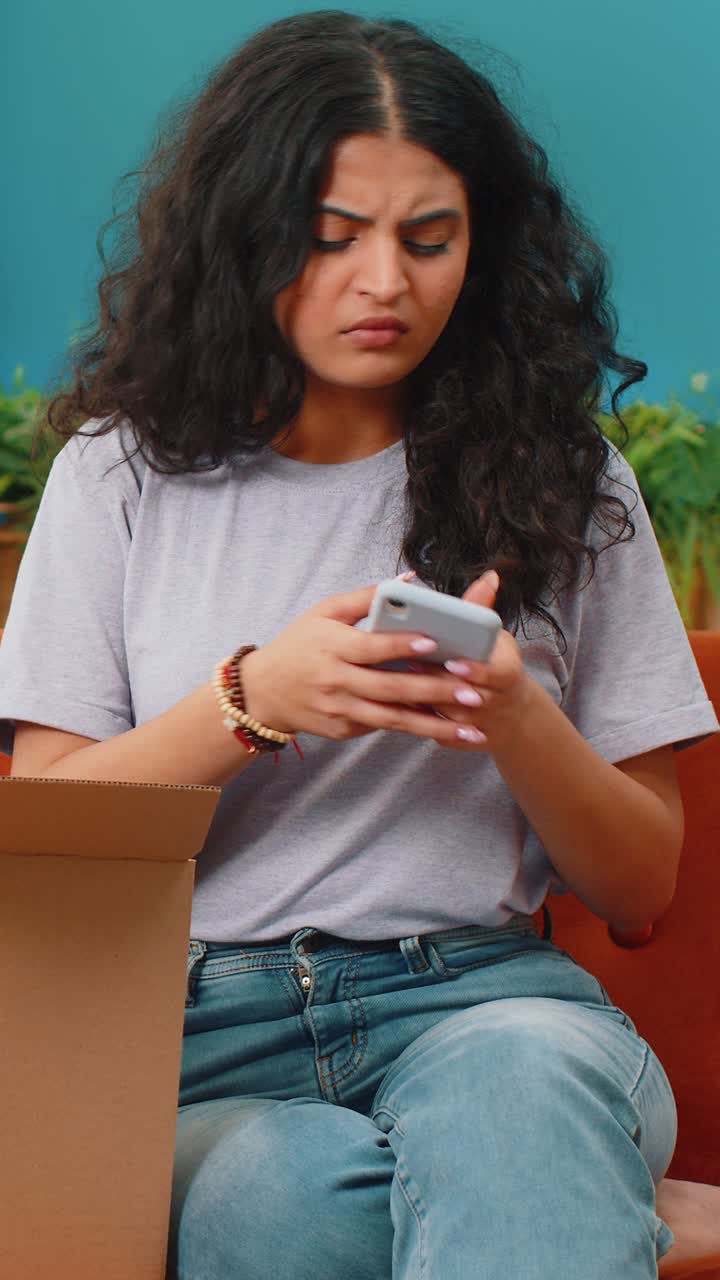 Angry dissatisfied shopper indian woman unpacking parcel feeling upset confused wrong delivery