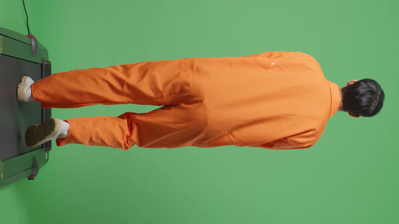 Person Walking on Treadmill in Orange Jumpsuit