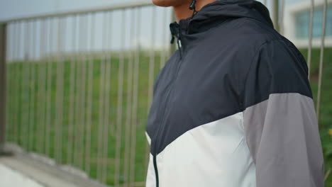 hand zipping sport jacket on street closeup. fitness man training in morning