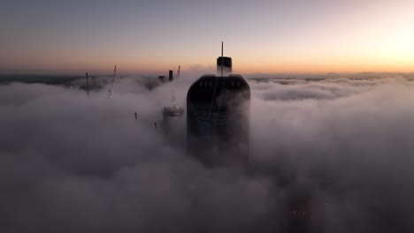 Aerial-shot-above-a-cloudy-foggy-Brisbane-City,-with-only-the-tops-of-sky-scrapers-being-visible