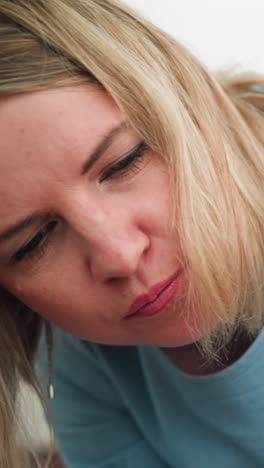 se ve a una mujer inclinada hacia adelante, dirigiéndose a alguien en el fondo, parece enfocada, con su atención dirigida hacia la persona con la que está interactuando