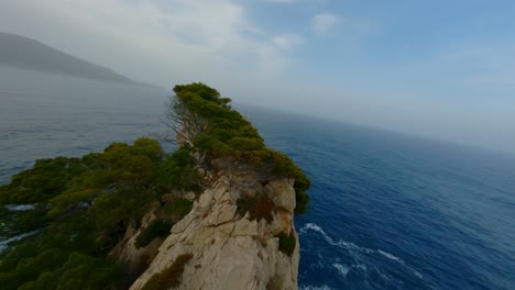 FPV-Drohne-Fliegt-über-Die-Küste-Von-Mallorca,-Folgt-Zwei-Möwen-Dicht-Und-Taucht-Die-Klippe-Hinunter,-Die-über-Die-Meereswellen-Fliegt