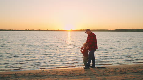 Feliz-Pasatiempo-Conjunto-Del-Abuelo-Y-El-Nieto-En-La-Naturaleza-El-Viejo-Y-El-Niño-Están-Pescando-En-La-Orilla-Del-Río