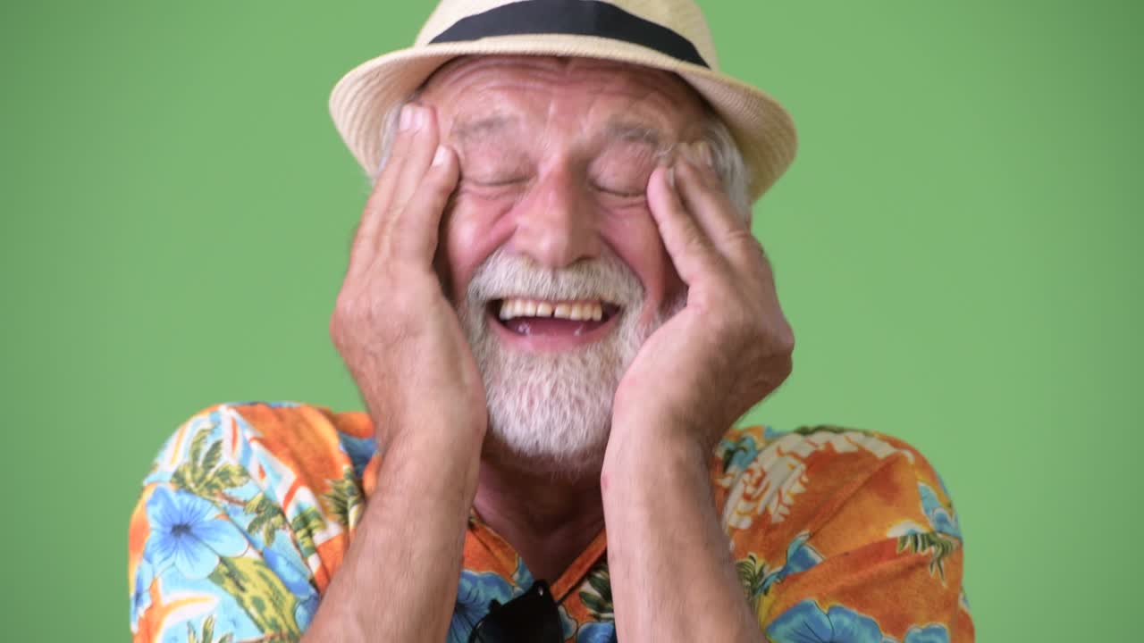 hombre turista barbudo y guapo listo para las vacaciones contra un fondo verde