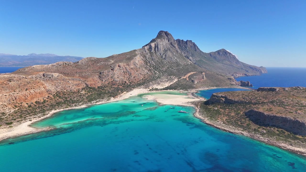 La Laguna di Balos mostra acque basse turchesi e spiagge sabbiose sotto la penisola di Gramvousa e Capo Tigani, Kissamos, Chania, Creta, Grecia, sorvolo in avanti con drone