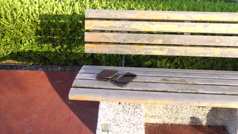teléfonos rotos y billetera en un banco del parque