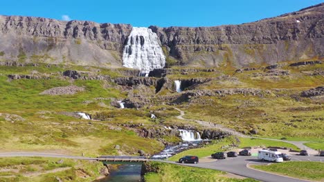 아이슬란드의 westfjords에있는 도로 dynjandi 폭포에서 운전하는 캠퍼 밴의 아름다운 공중 샷