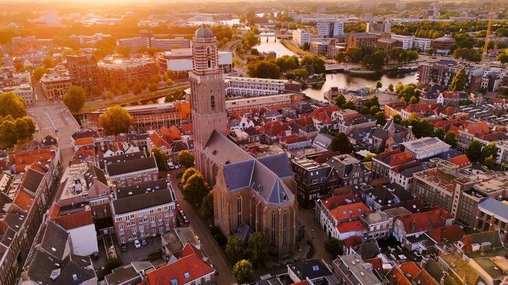 Veduta aerea all'ora d'oro di Zwolle, Paesi Bassi, con il Peperbus e la Basilica di Nostra Signora che si ergono sopra fitte strade storiche, tetti rossi e canali nella calda luce del tramonto