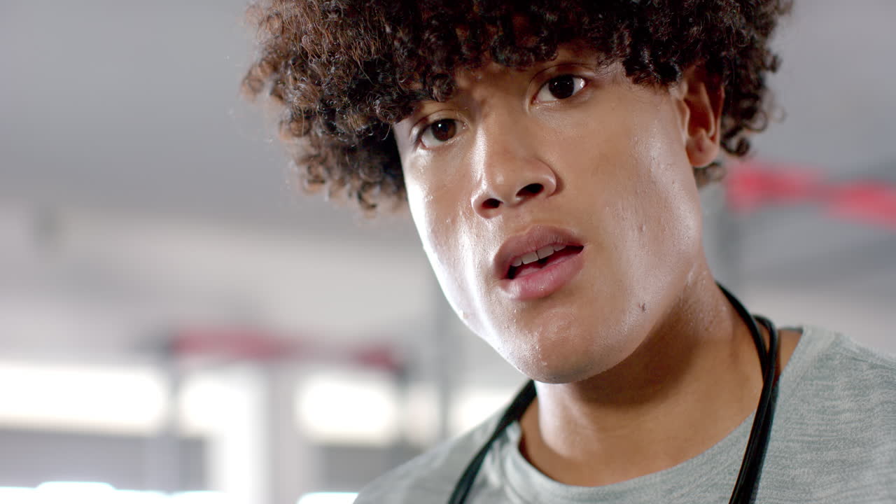 Close-up of man with curly hair wearing gym attire and stethoscope
