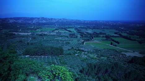 Drohnenaufnahme-über-Der-Weiten-Landschaft-Frankreichs-Mit-Quellen-Und-Kleinen-Bauernhäusern-Und-Felsen-Am-Horizont