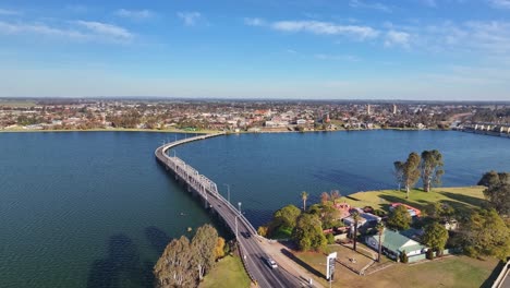 aerial rise up over the road bridge with the town of yarrawonga victoria australia beyond