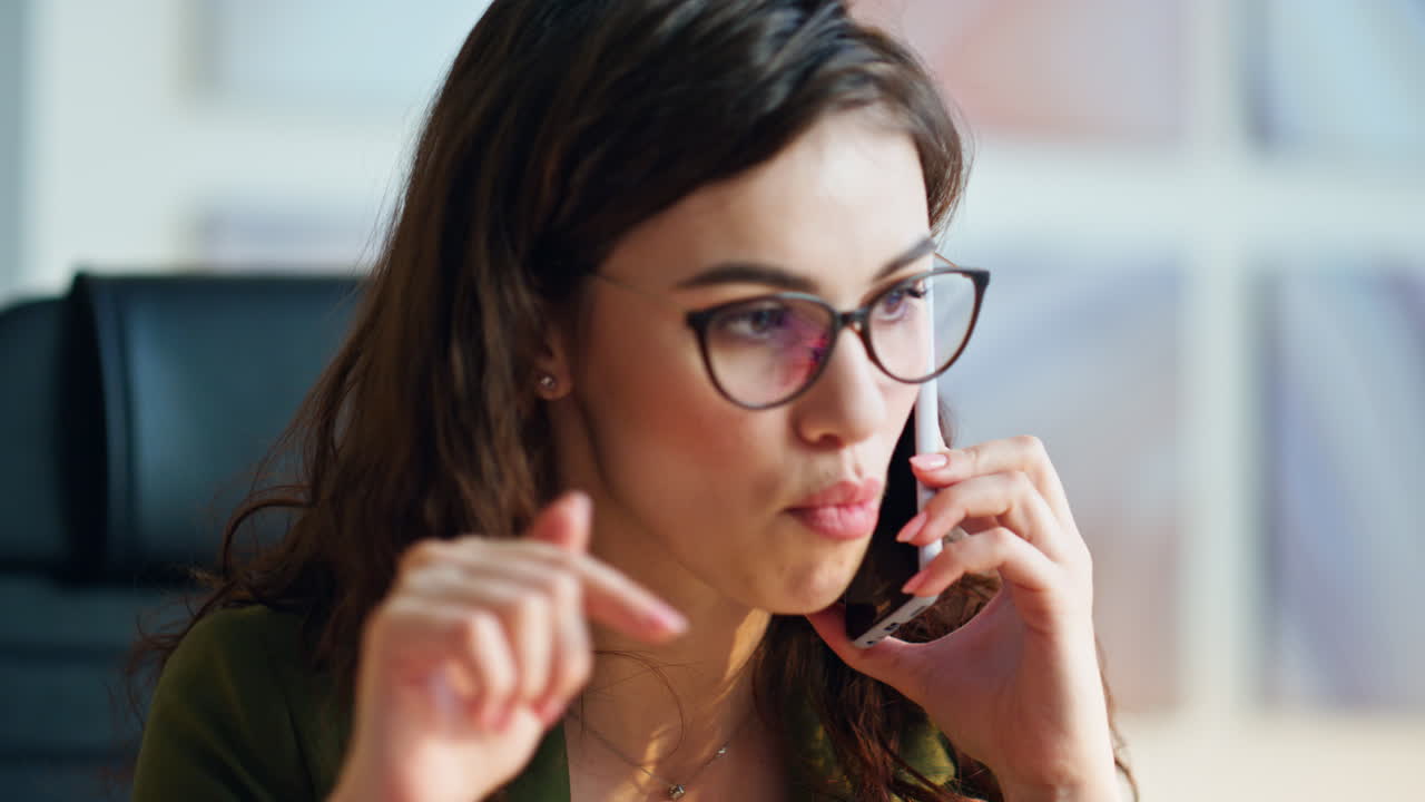 Portrait nervous businesswoman speaking cellphone in office. Woman calling phone