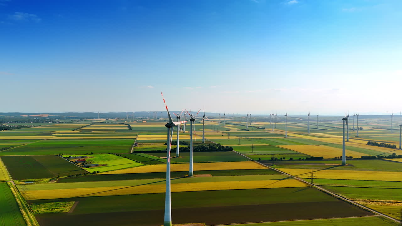 Modern wind farm in the picturesque countryside. Multiple wind turbines produce clean energy. Aerial view.