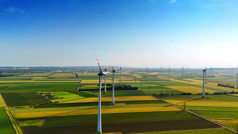 modern wind farm in the picturesque countryside. multiple wind turbines produce clean energy. aerial view.