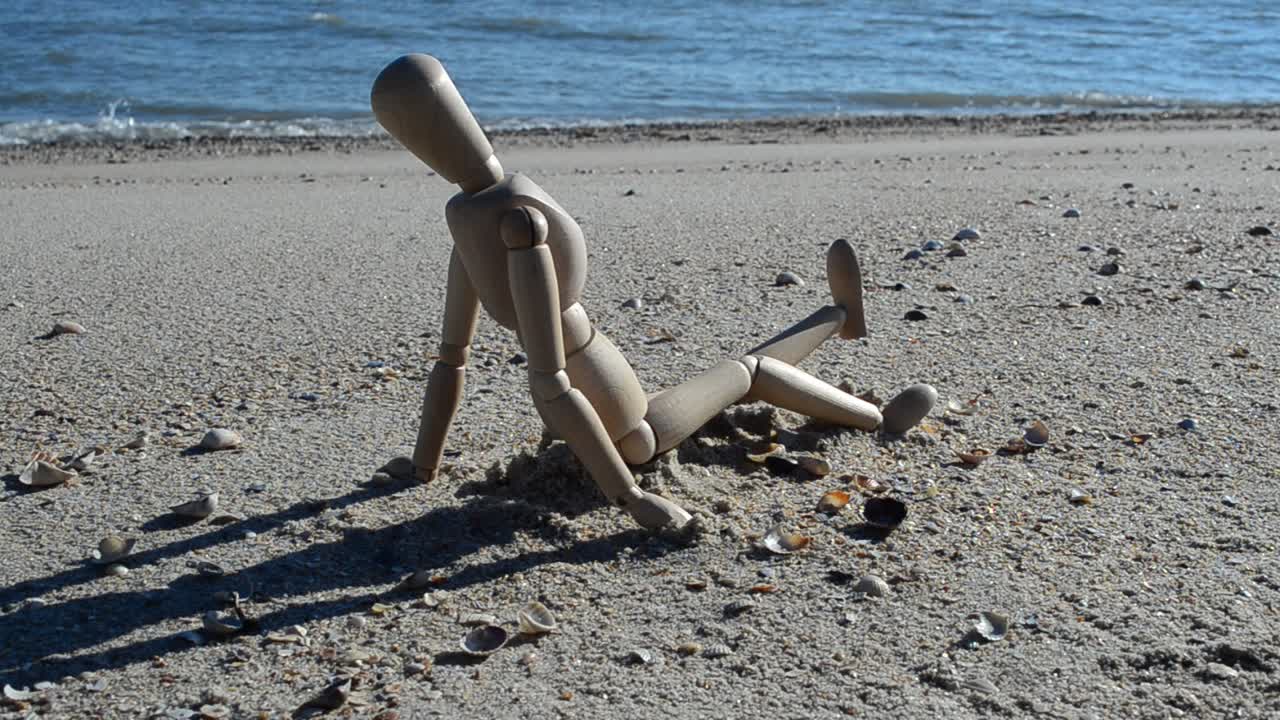 Manichino di legno sulla spiaggia. Riprese sulla spiaggia