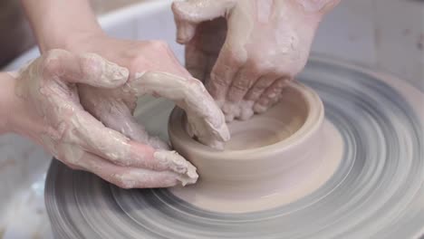 the master potter teaches the child to work with clay on a potter's wheel.