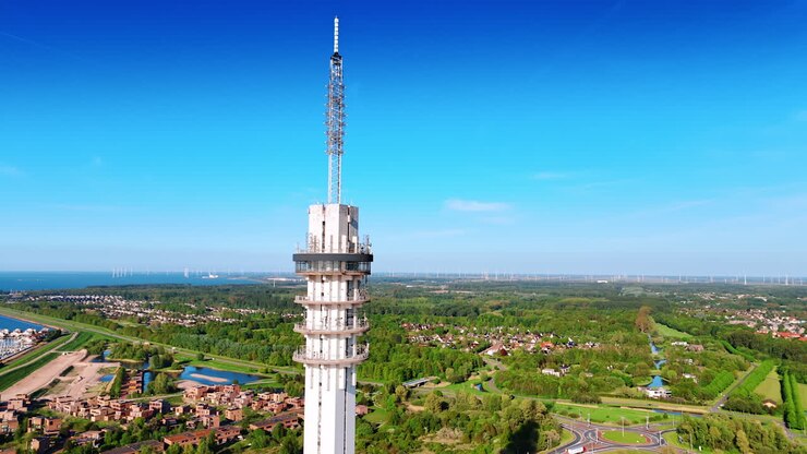 Top of the telecom tower in Lelystad, the Netherlands. Revealing view on the green cityscape and yacht club. Aerial view.