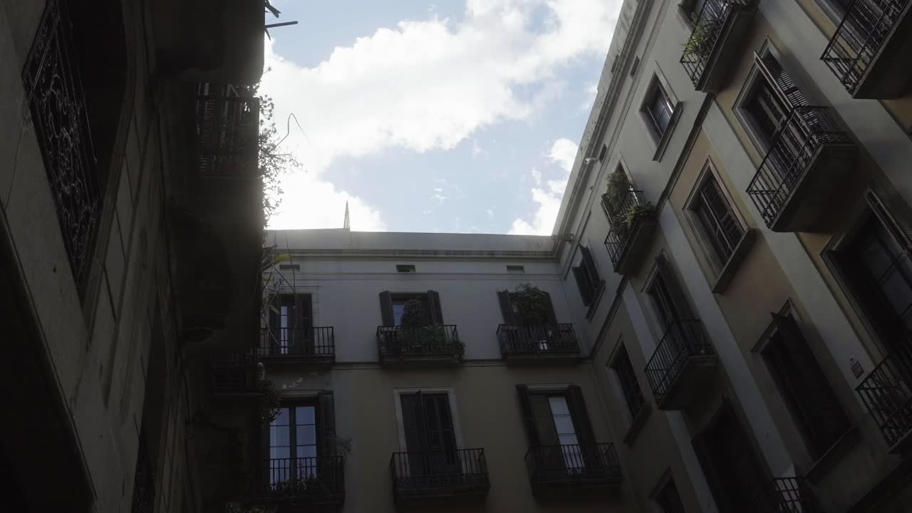 un barrio de barcelona, españa, con nubes brillantes y pájaros en una toma de ángulo bajo